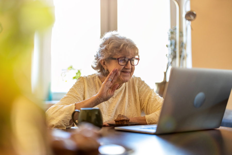 Happy senior woman using laptop at home