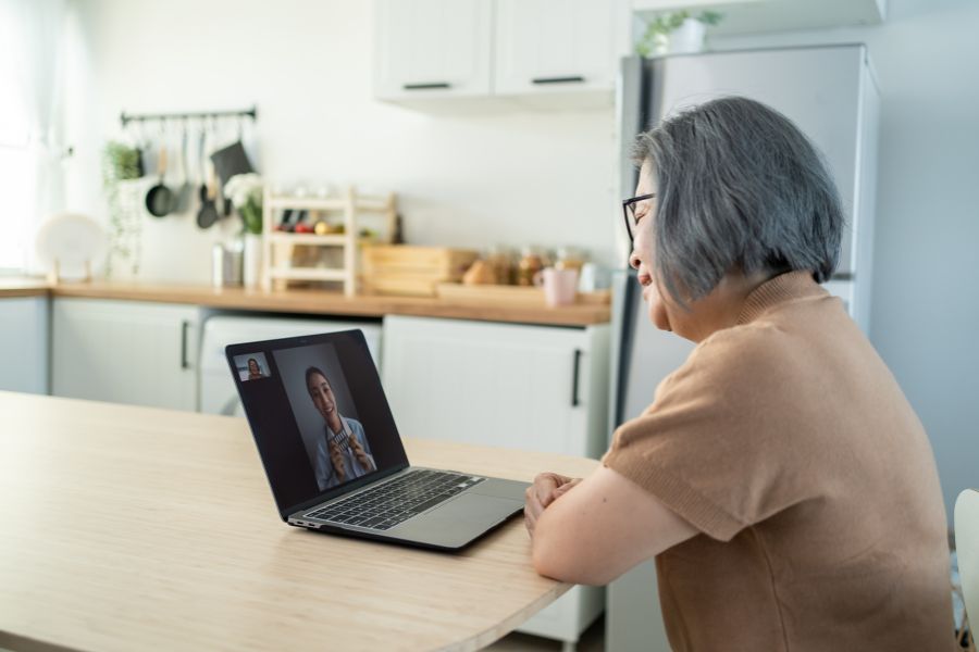 senior older woman video call with doctor in living room at home